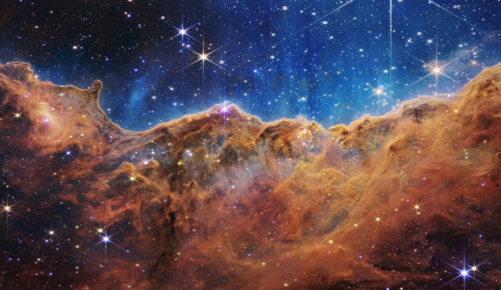 The Cosmic Cliffs in the Carina Nebula (NGC 3324): orange gas and dust ridges under a blue star field