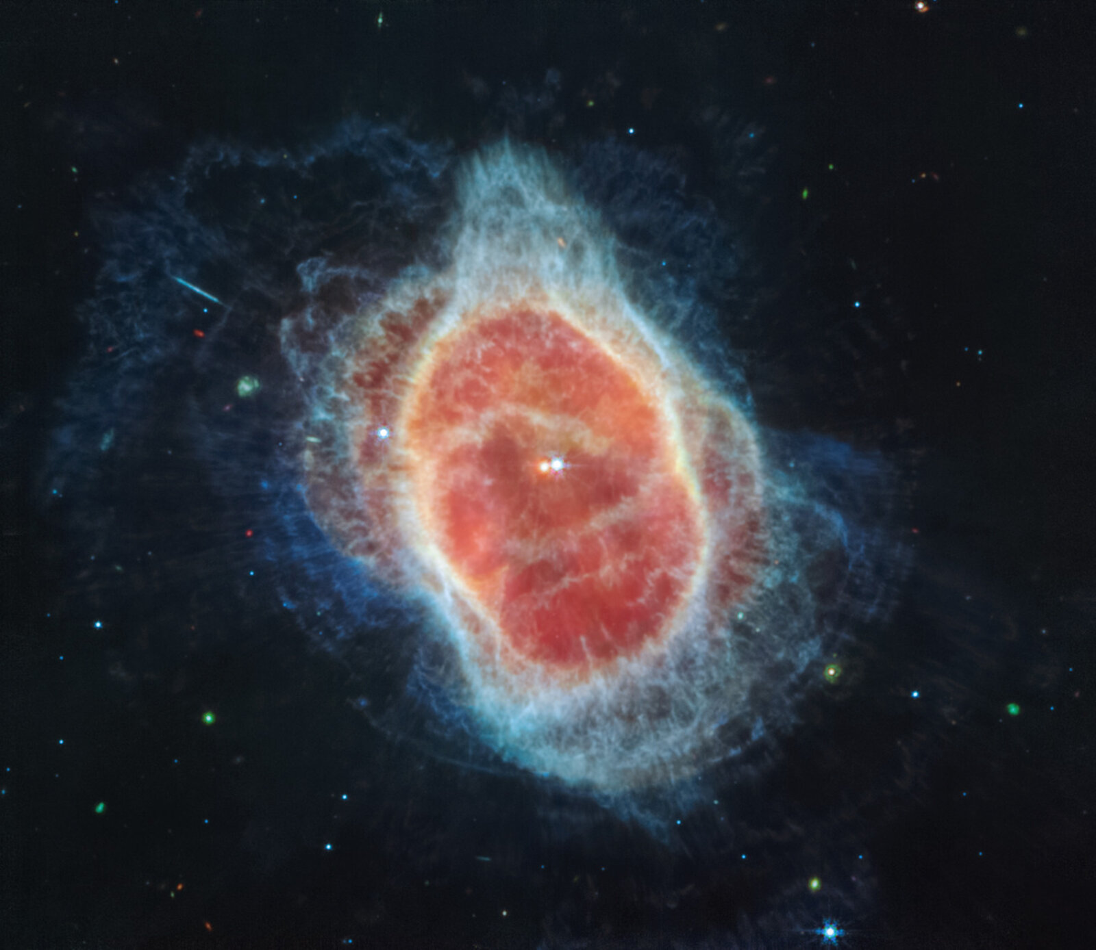 The Southern Ring Nebula in mid-infrared (MIRI): a red center ringed by pale blue shells of gas